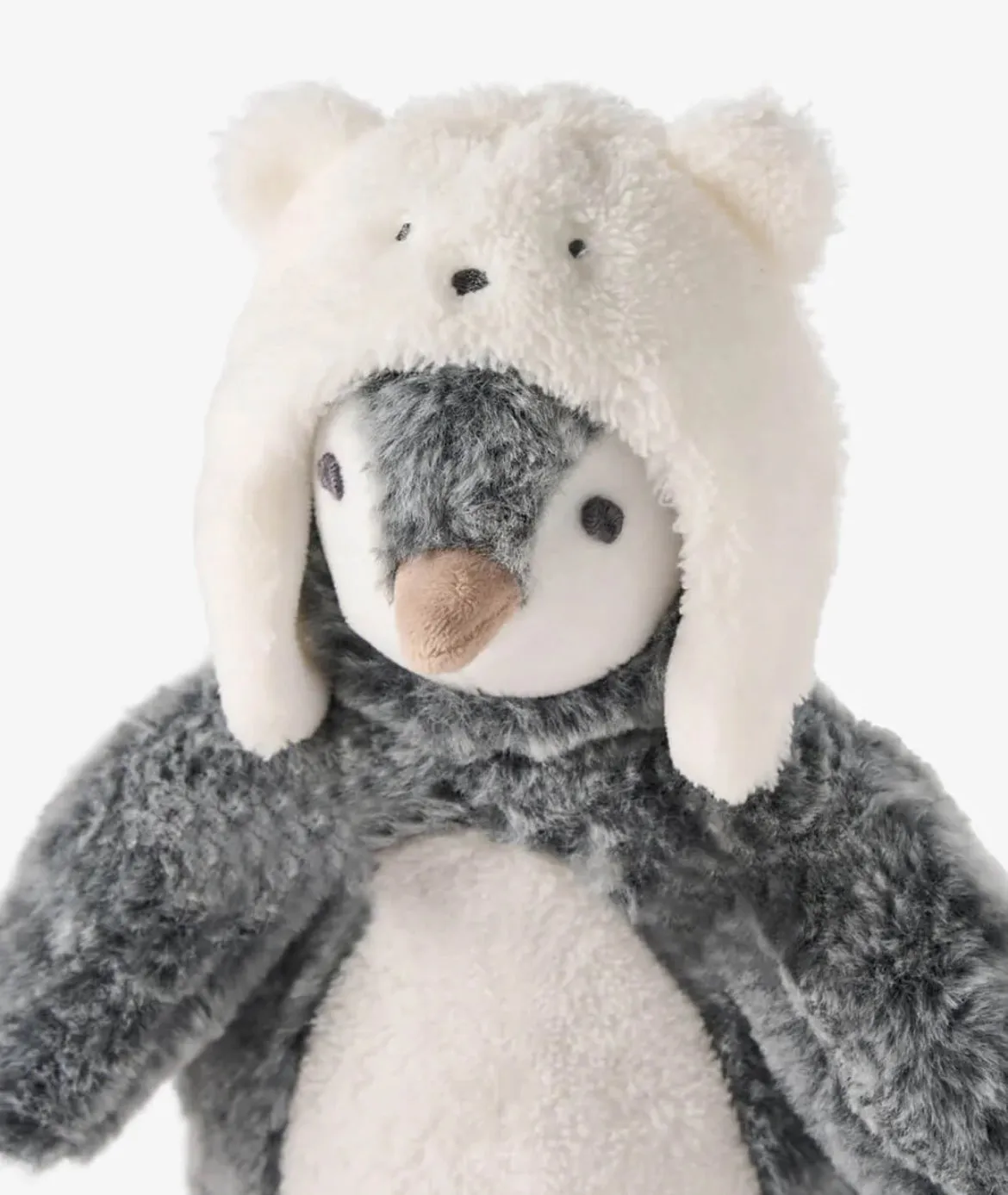 Penguin wearing a polar bear hat stuffed toy