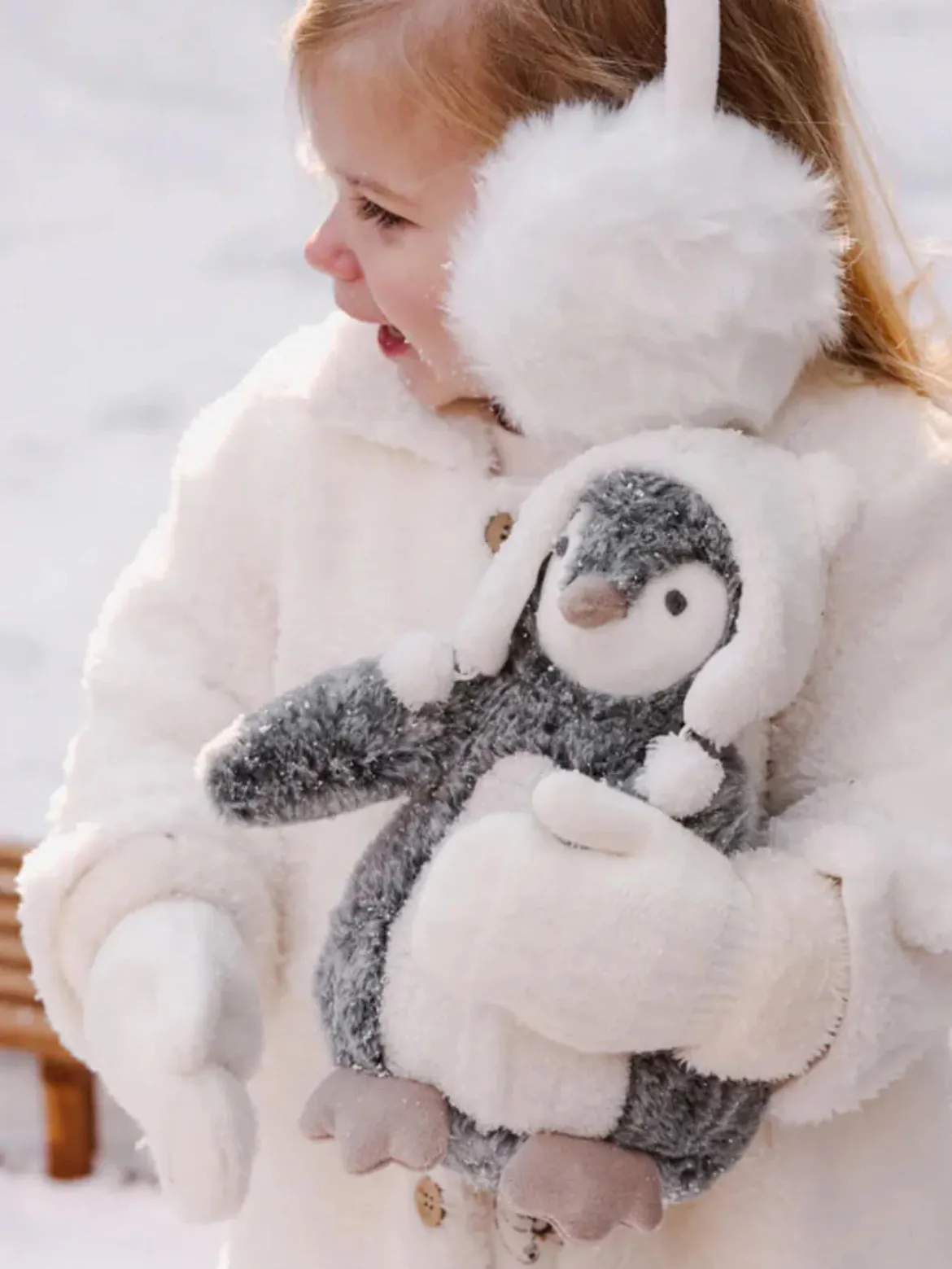 Penguin wearing a polar bear hat stuffed toy